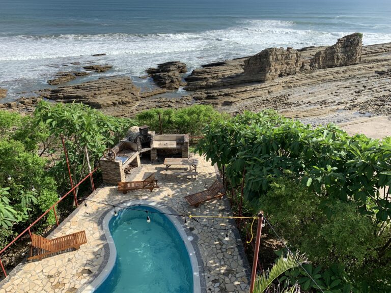 A beach in Nicaragua with a cliff edge, with a pool in the back patio.